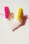 Pink and yellow clothespins hold a white textured heart on a rope