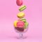 Pink, yellow, green macarons in glass vase. Flying dessert