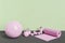 Pink yoga equipment in room with green wall