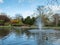 Pinner Memorial Park, Middlesex, UK taken on a sunny partially cloudy spring day, showing lake with fountain, birds, ducks