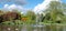 Pinner Memorial Park, UK. Photo shows lake with water fountain, birds, ducks, geese, trees and green foliage.