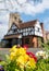 Pinner Parish Church in the High Street, Pinner Middlesex, UK with historic half timbered building in front. Colourful primula flo