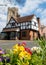 Pinner Parish Church in the High Street, Pinner Middlesex, UK with historic half timbered Tudor building in front. Primula flowers