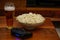 Pint of beer bowl of popcorn and gamepad on wooden background home entertainment