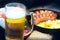 Pint of frothy beer in a misted glass, on the background of a delicious dinner