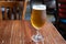 Pint glass of british light pilsner ot lager beer served in old vintage English pub