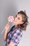 Pinup beautiful girl in checkered shirt poses with lollipop