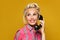 Pinup woman answers a phone call. Beautiful retro girl with red lips makeup and old fshion hairstyle