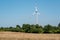 Pinwheel behind a dry meadow and a row of trees