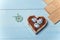 Pinwheel with bird and flowers, heart shaped box with decorated Easter eggs and brown boards on wooden blue background
