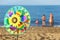 Pinwheel toy on beach, family standing in water