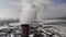 A pipe with white puffs of smoke. Pipes of a city gas boiler house with white smoke against the winter sky. Aerial close