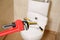 Pipe wrench near toilet indoors