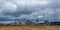 Pipes of woodworking enterprise plant sawmill against a gloomy gray sky. Air pollution concept. Panorama of industrial landscape