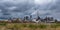 Pipes of woodworking enterprise plant sawmill against a gloomy gray sky. Air pollution concept. Panorama of industrial landscape