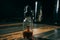 Pipette dropping essential oil into a glass bottle on wooden background