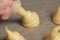 Piping choux dough for profiteroles on baking paper