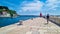 Piran - Tourist man walking along picturesque harbor of coastal town Piran