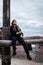 A pirate girl with a dirty face sits on a ship against a cloudy sky