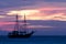 Pirate sailboat on sea navigating towards the sunset