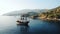 Pirate ship with lowered sails drifts on azure sea during calm arriving to hilly coast