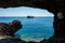 Pirate ship sailing in the sea. View from a cave