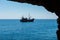 Pirate ship sailing in the sea. View from a cave