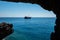 Pirate ship sailing in the sea. View from a cave