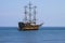 Pirate ship, yacht, three-masted against the blue sea and blue sk