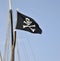 The pirates flag, the jolly roger, waving on a blue sky background