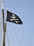 The pirates flag waving on a blue sky background