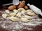 Pirogues, pierogi , Ukrainian food, on wooden table with rolling pin.