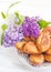 Piroshki - russian baked puff pastry with cabbage fillings and bouquet of lilacs. Traditional russian cabbage stuffed baked pastry