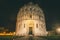 The Pisa Baptistery of St. John close to the leaning tower of pisa at night.