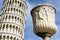 Pisa, Italy. September 16, 2023. Roman statues and vases with the leaning tower of Pisa in the background