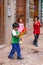 Pisac, Peru - 02.23.2020: Peruvian kids playing with foam toy-guns on the streets of Pisac