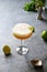 Pisco sour cocktail - whiskey with lime, egg white, syrup in glass on grey table. Vertical shot