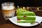 Pistachio cake with kiwi, cream and raspberry filling and Cappuccino coffee