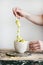 Pistachio ice cream in mug and spoon in woman`s hand