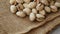 Pistachios in burlap sack on concrete table. Organic pistachios. Vegan Healthy food high protein. Dietary nutrition