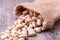 Pistachios nut in burlap sack on grained wood background
