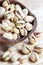 Pistachios in a wooden bowl on light background.