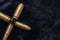 Pistol bullets gathered together in the shape of a cross. War concept. Dark background shot