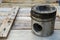 Piston of engine on wooden background, Auto parts industry and spare parts background, piston damage in hard works