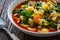 Pistou soup Nice - broth with basil pesto, noodles and vegetables on wooden background in white bowl