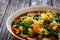 Pistou soup Nice - broth with basil pesto, noodles and vegetables on wooden background in white bowl