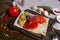 The pita bread is served with grilled vegetables zucchini, red pepper, a skinless tomato on a dark cutting board, a linen napkin