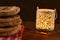 Pita breads or arabian bread stacked on a rustic cloth and a cutting board on a wooden table with black background