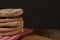 Pita breads or arabian bread stacked on a rustic cloth and a cutting board on a wooden table with black background