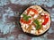 Pita with chicken and vegetables on a round plate, basil herbs on a brown spotted background